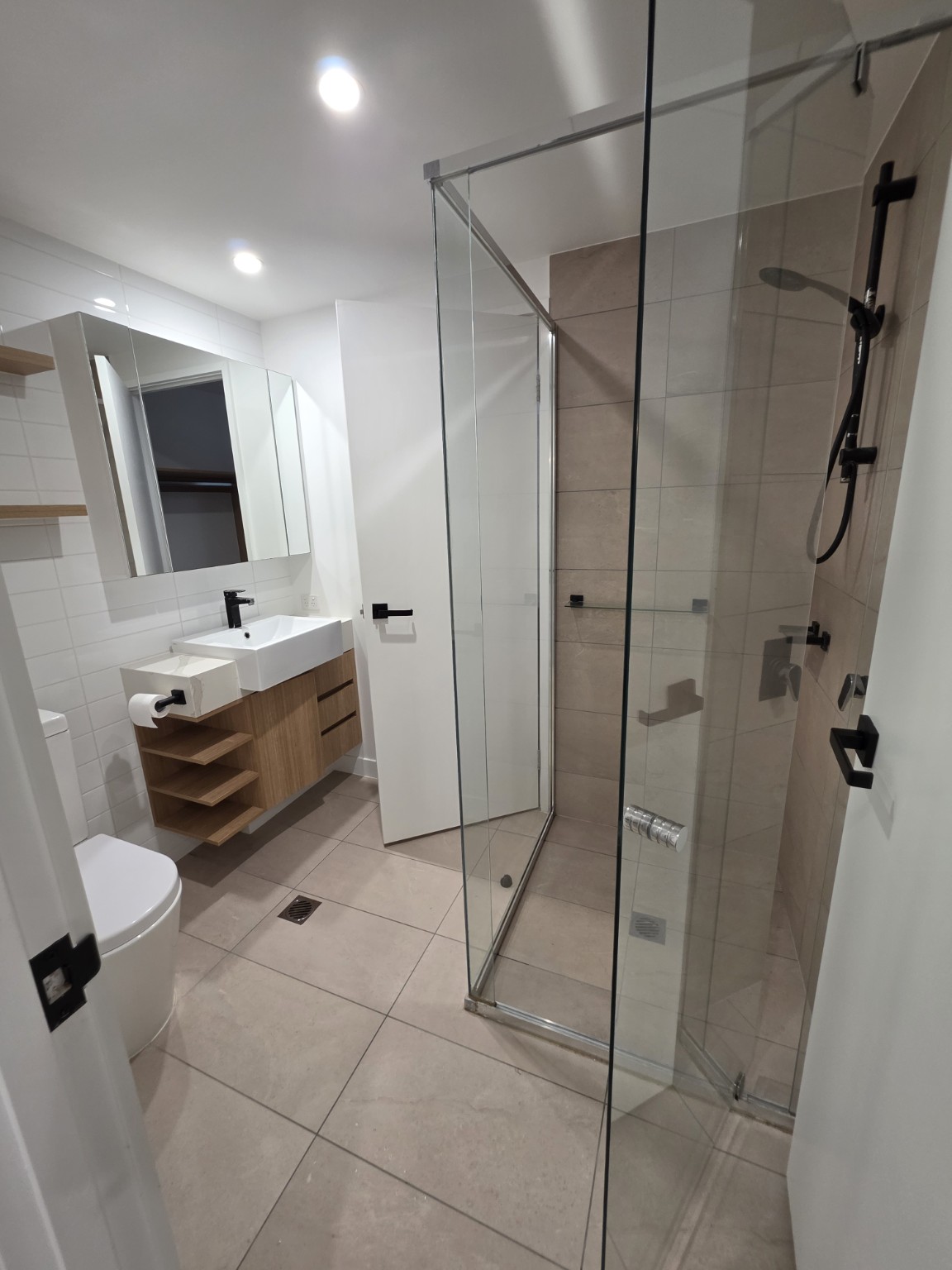 Bathroom with a timber vanity, white basin and glass shower
