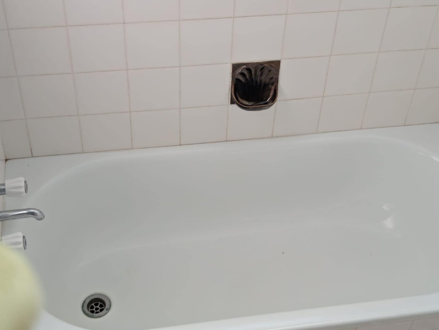 The same bathtub after cleaning, showing the cleared basin and surround